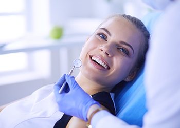 A young female smiling at her dentist during a regular checkup and cleaning
