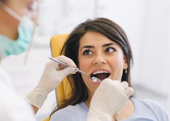 A young woman having her teeth checked while in the dentist’s chair