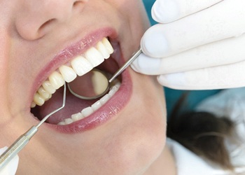 A woman having porcelain veneers looked at by a dentist