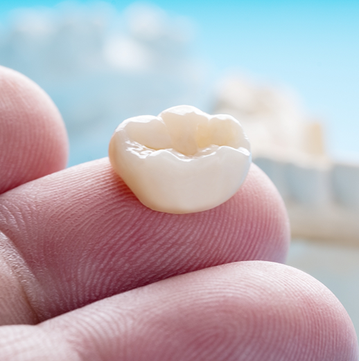 Dental crown resting on a finger