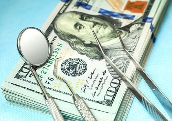 Dental instruments on top of a stack of cash