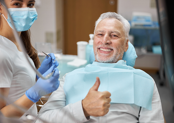 Senior man giving a thumbs up in the dental chair