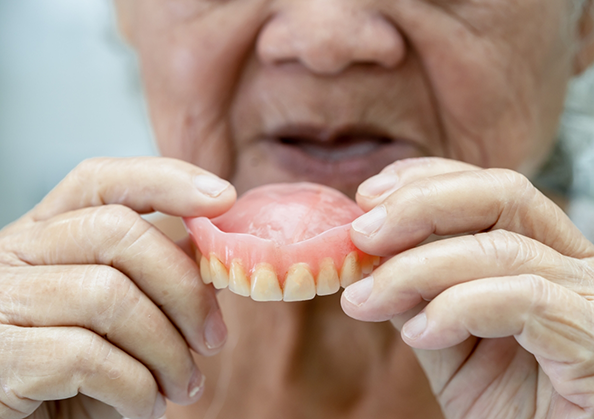 Senior person holding a denture