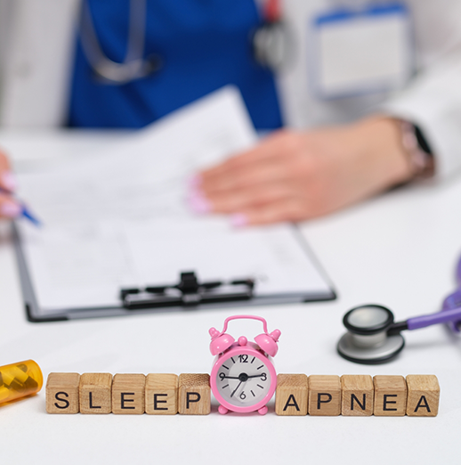 Dentist sitting at a desk with wooden block letters spelling out sleep apnea