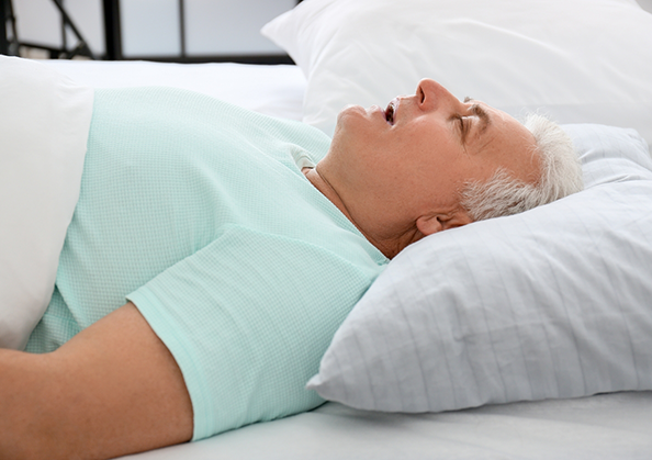 Older man sleeping on his back with his mouth open