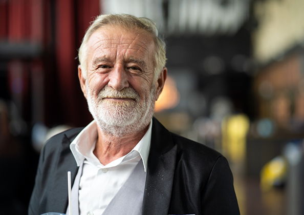 Older man smiling in a suit