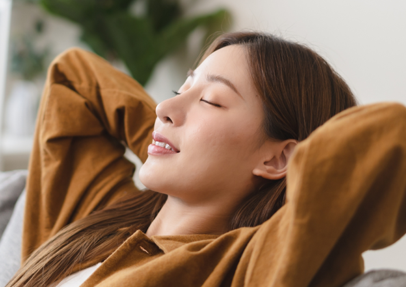 Relaxed woman with her eyes closed and her hands behind her head