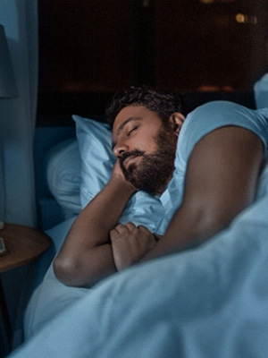 Man sleeping on his side in bedroom