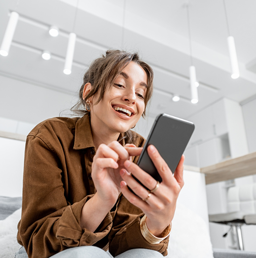 Woman smiling while looking at her phone